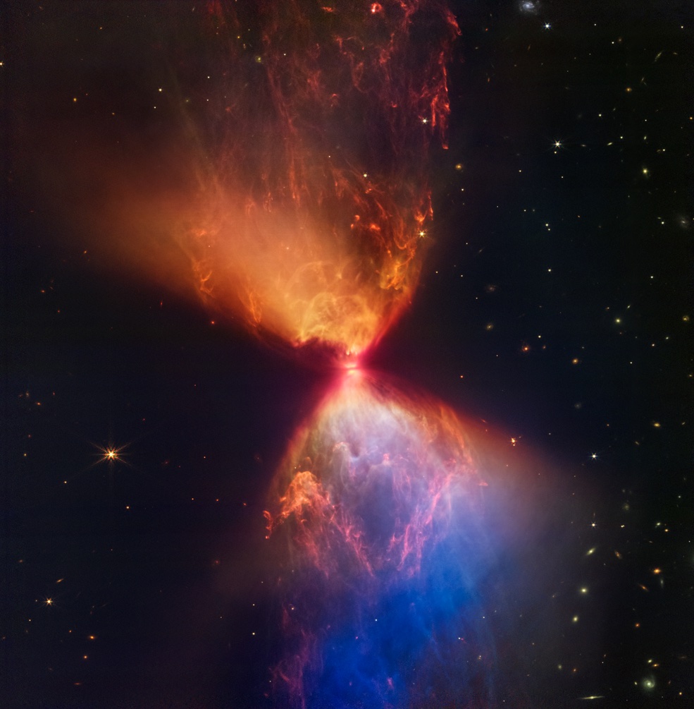 The protostar within the dark cloud L1527, shown in this image from NASA’s James Webb Space Telescope Near-Infrared Camera (NIRCam), is embedded within a cloud of material feeding its growth. Ejections from the star have cleared out cavities above and below it, whose boundaries glow orange and blue in this infrared view. The upper central region displays bubble-like shapes due to stellar “burps,” or sporadic ejections.
Credits: NASA, ESA, CSA, and STScI. Image processing: J. DePasquale, A. Pagan, and A. Koekemoer (STScI)
Download the full-resolution image from the Space Telescope Science Institute.